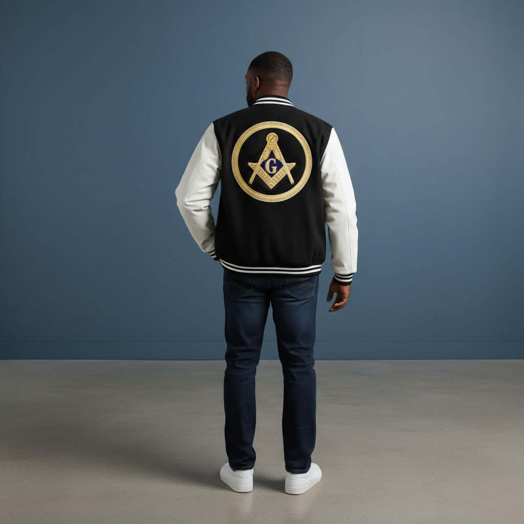 Man wearing a Mason Coat with a logo on the back, standing against a blue wall.